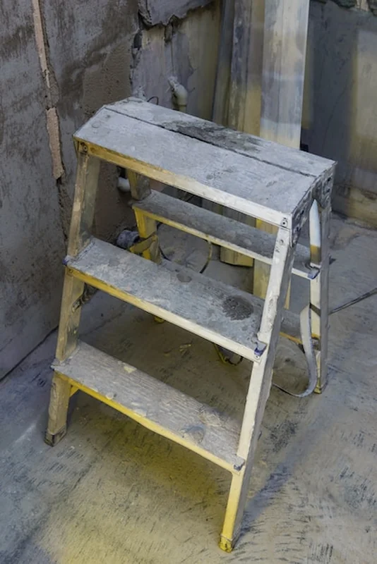 Drabina wzdłuż szarej betonowej ściany