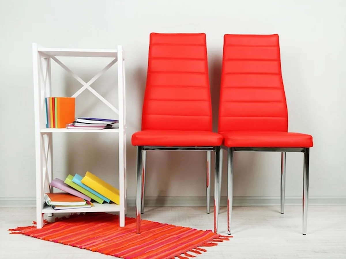 Nowoczesne kolorowe krzesła z książkami na drewnianym stojaku