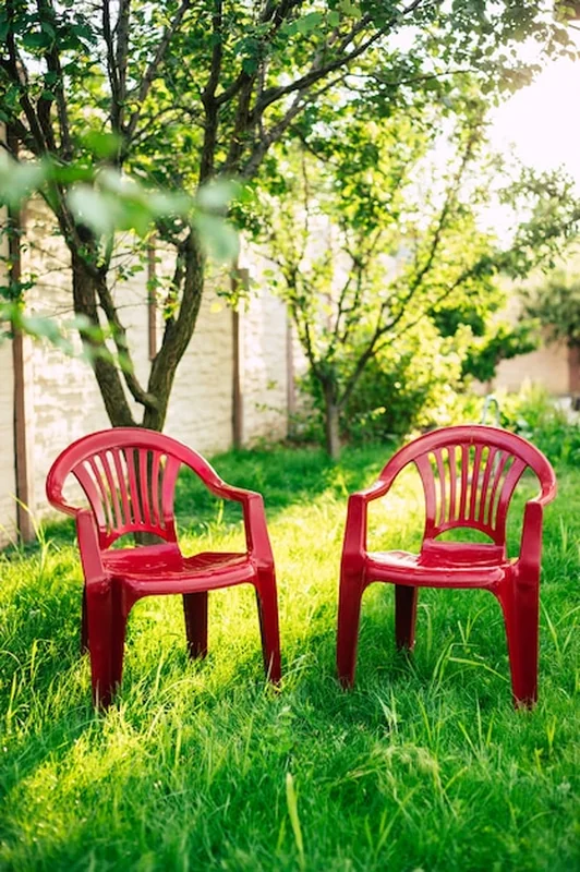 Czerwone letnie krzesło w ogrodzie obok domu