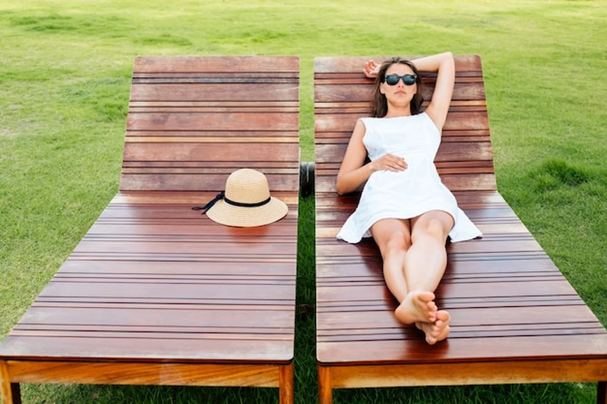 Piękna młoda kobieta leży na leżaku