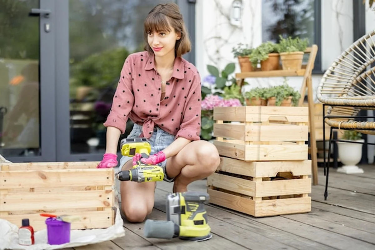 Gospodyni naprawia drewniane skrzynki na tarasie