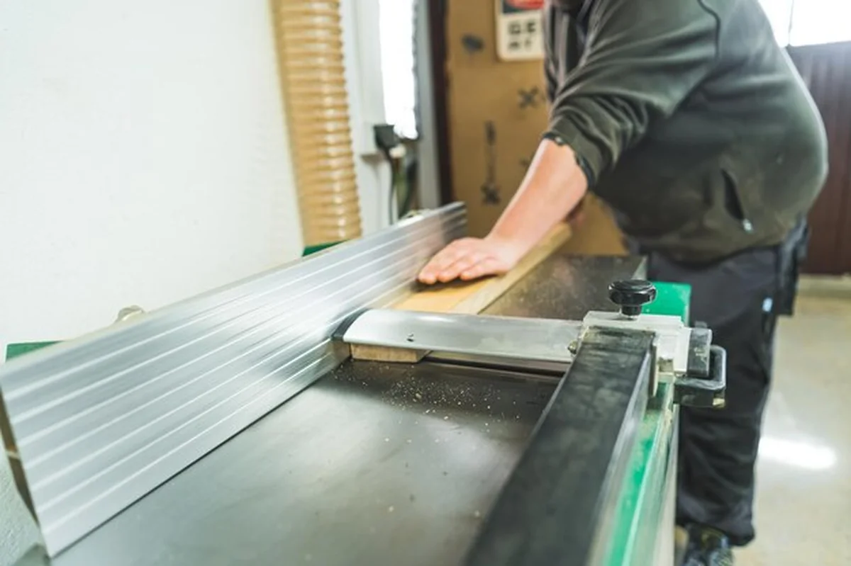 Stolarz cięcie deski drewnianej profesjonalnymi maszynami