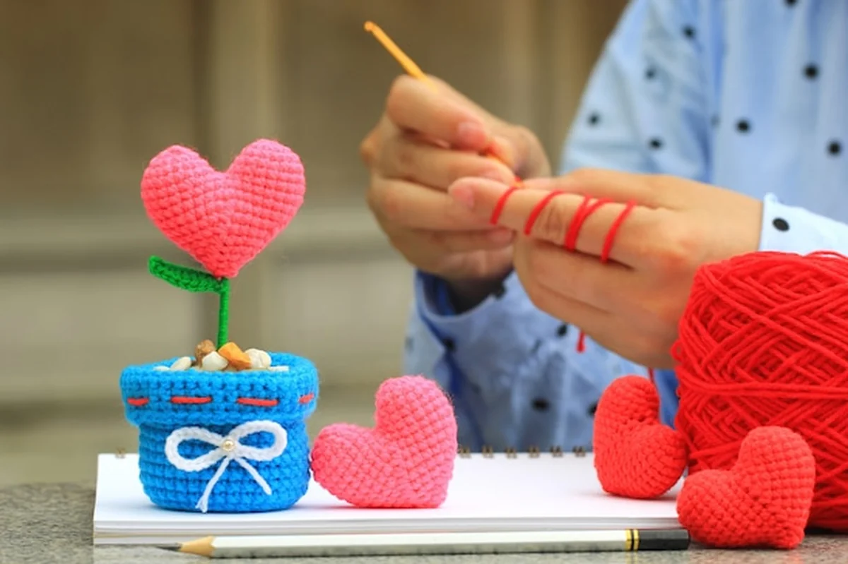 Kobieta szydełkuje serce z włóczki