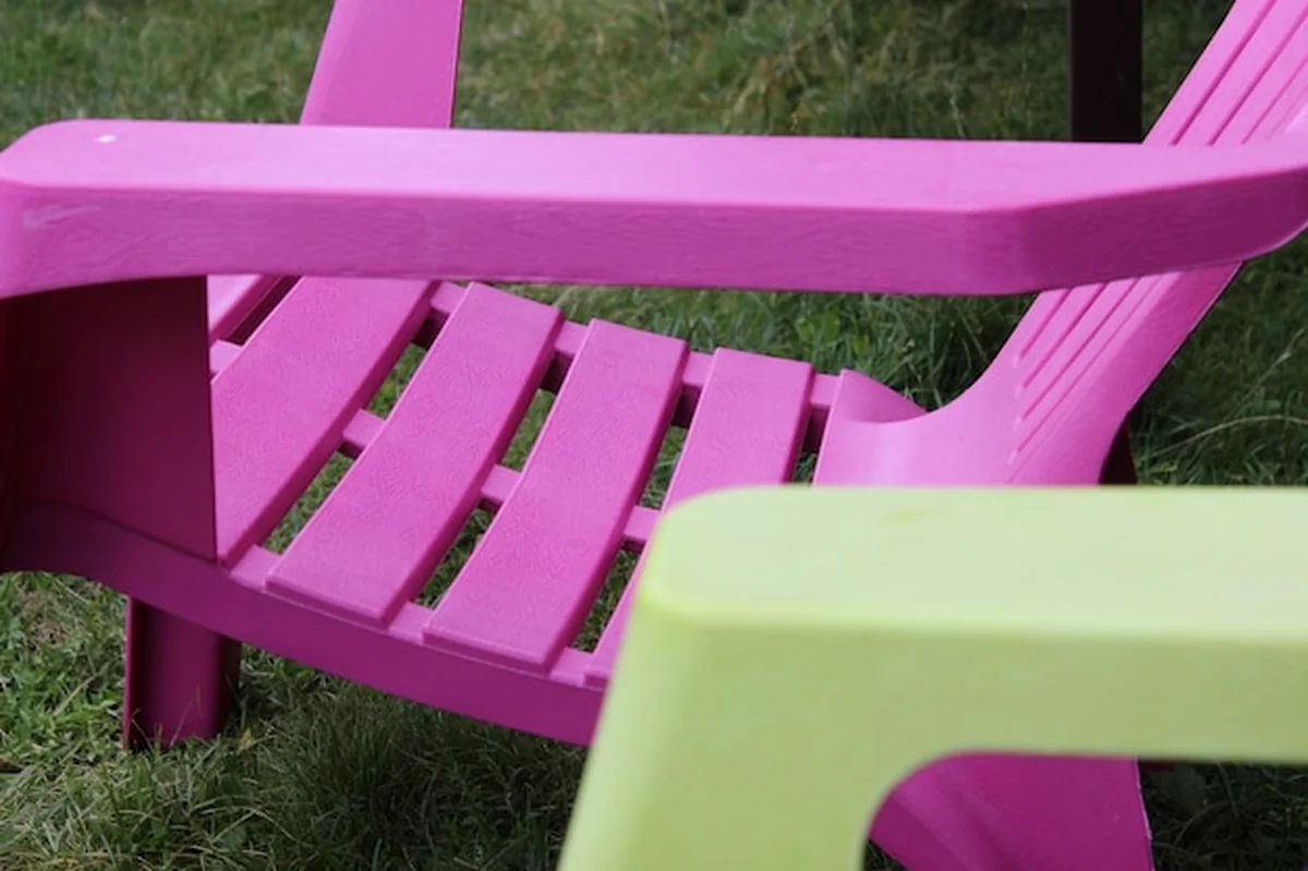 Puste plastikowe krzesła na trawiastym polu