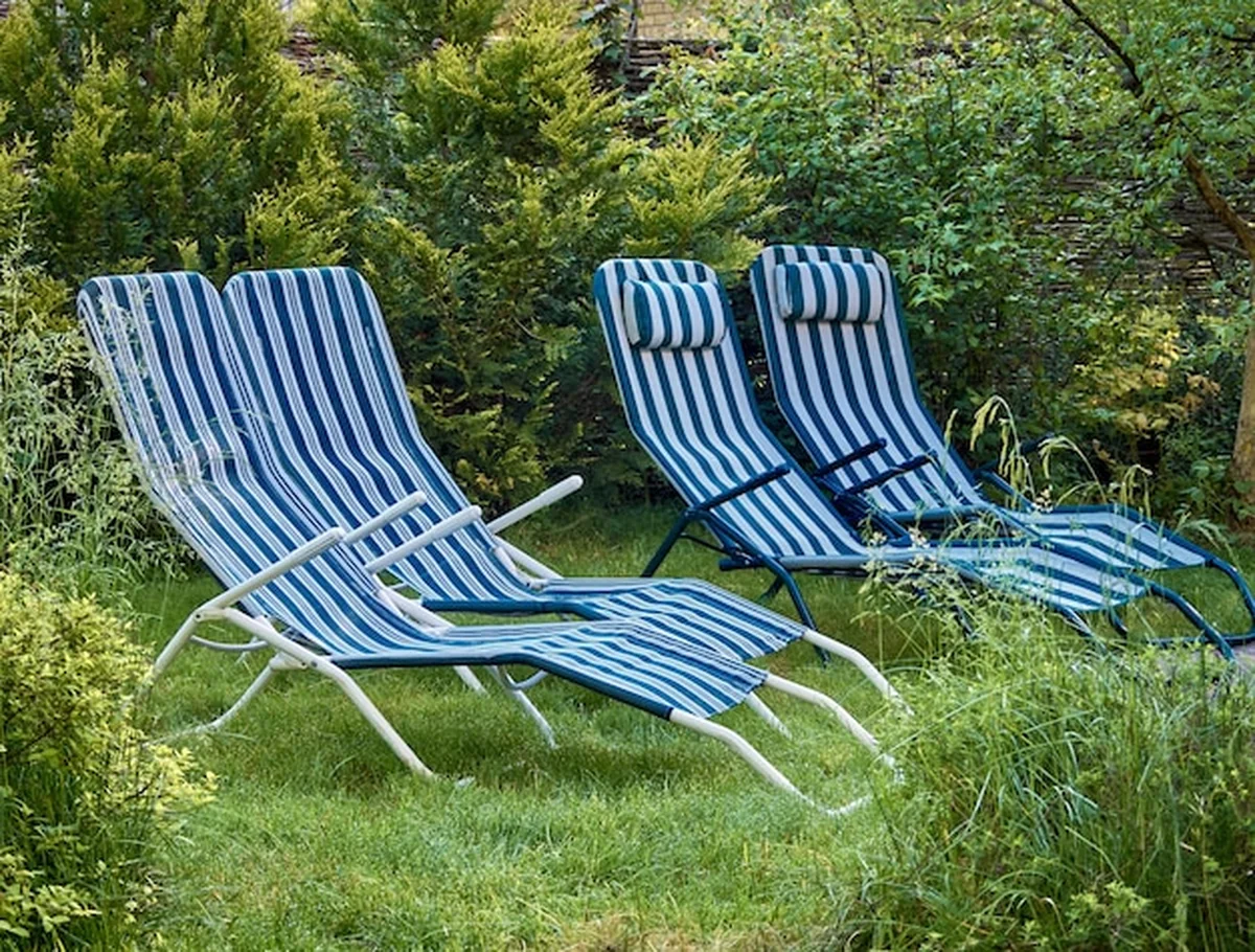 Część ogrodu z trawnikiem i leżakami w paski